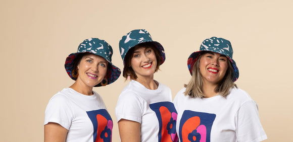 Three women wearing hats and t - shirts.