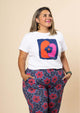 The 2023 Sandra Tee has intersecting orange and pink arches with a flower on a royal blue background